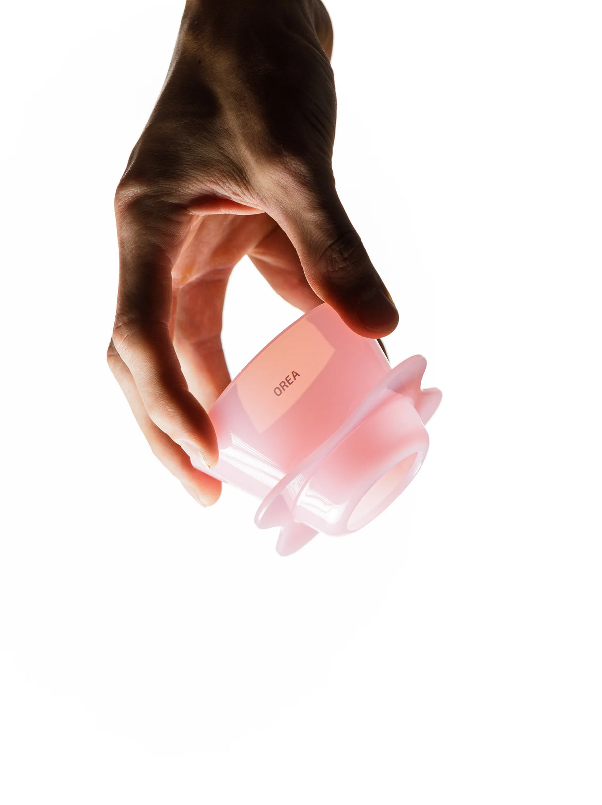 Hand holding a Creamy pink OREA 01 brewer on a white background