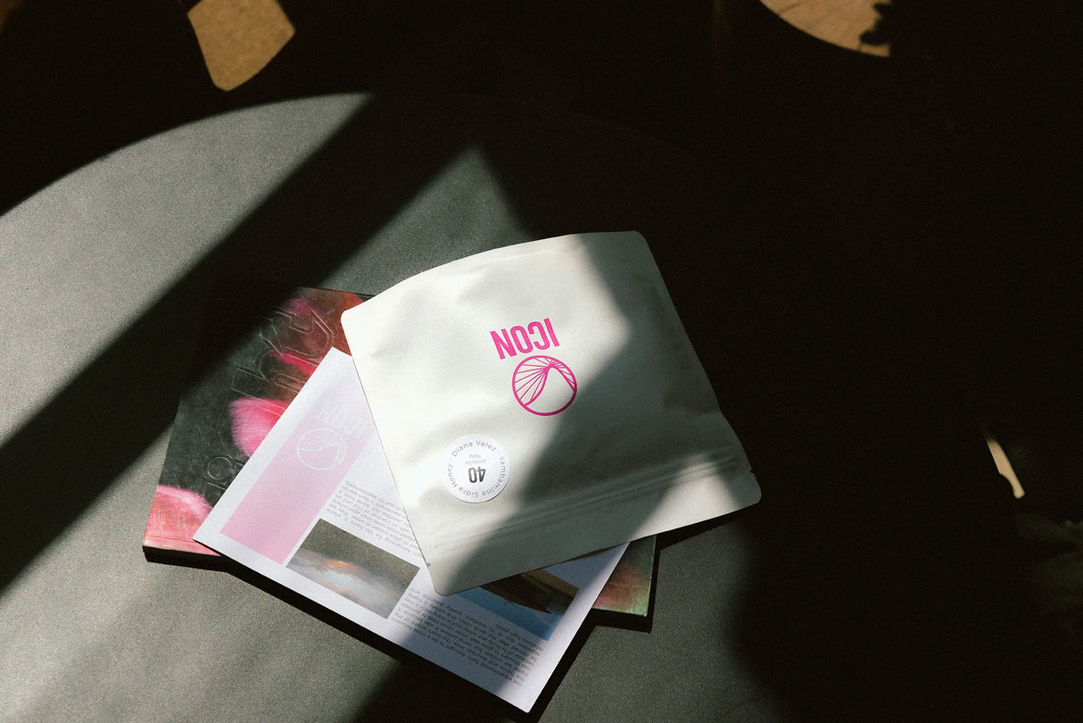 Dramatically lit ICON subscription coffee packaging on a coffee table.