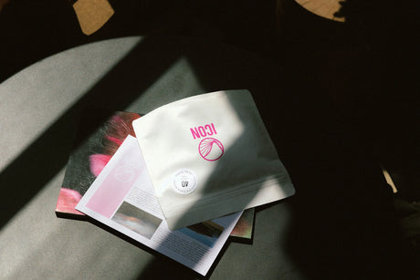 Dramatically lit ICON subscription coffee packaging on a coffee table.