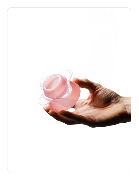 Hand holding a Creamy pink OREA 01 brewer against a white background
