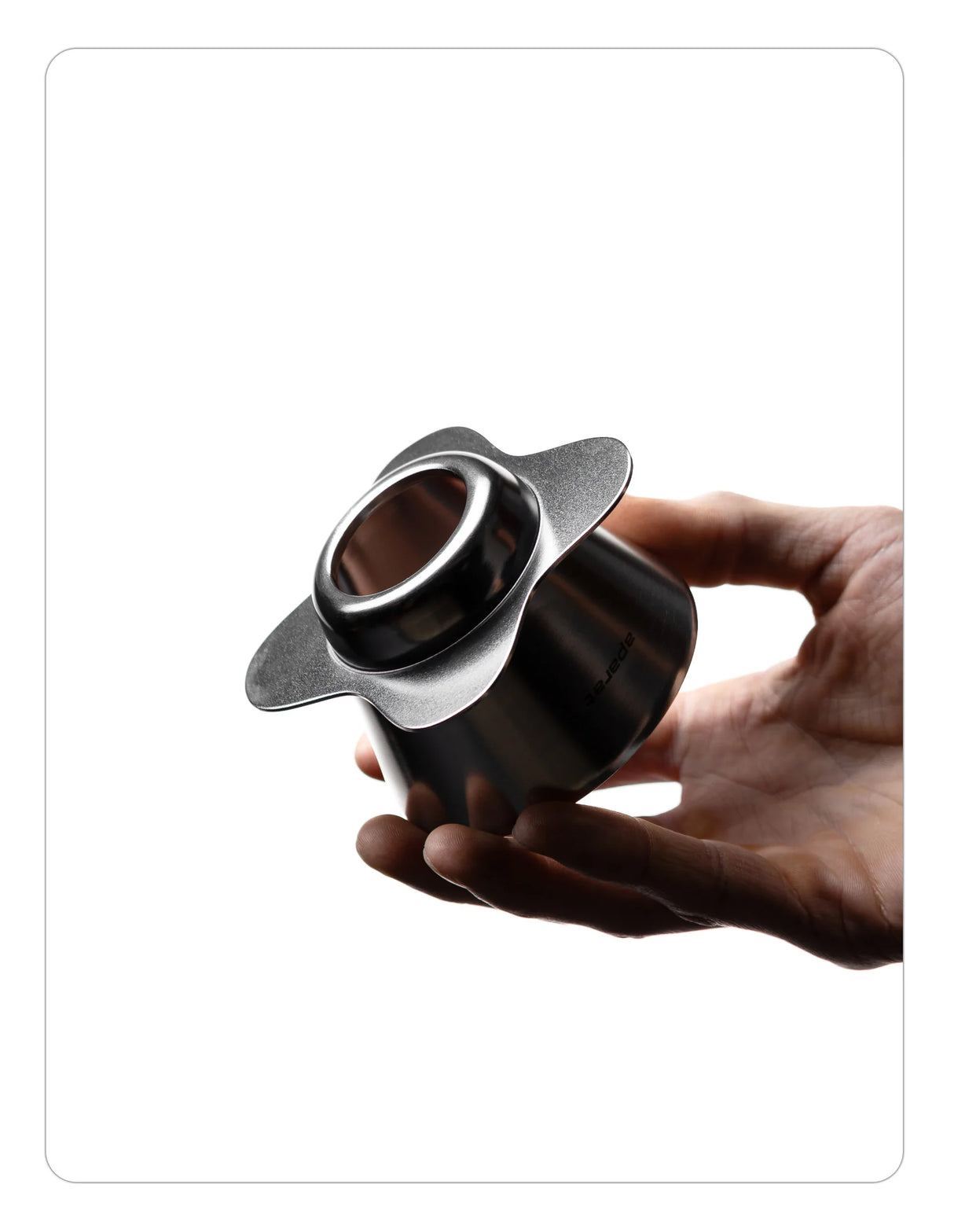Hand holding an OREA 01 raw steel coffee dripper with a white background